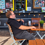 Helmut entspannt an einem Tisch bei Jills Wurstbruzzlerei