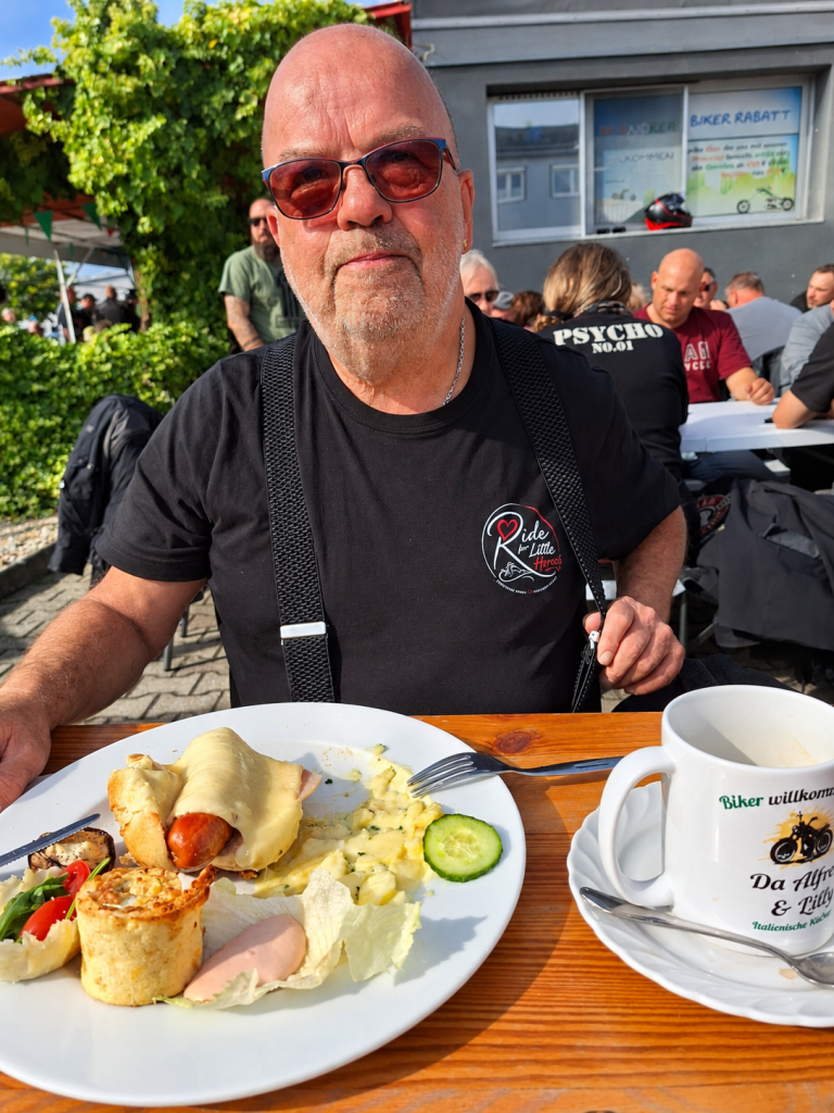 Mann beim Frühstück an einem Tisch während eines Bikertreffens in Kronau